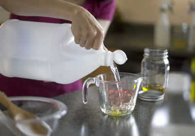 Imagen de vinagre vertida en una taza para limpieza de sobres de cocina